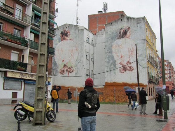 Graffiti sobre medianera que representa dos personas que parecen mani atadas. Sobre ellas se leen las palabras Ayuntamiento de Madrid