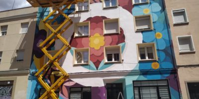Mural que cubre todo un edificio con motivos florales y de mucho colorido